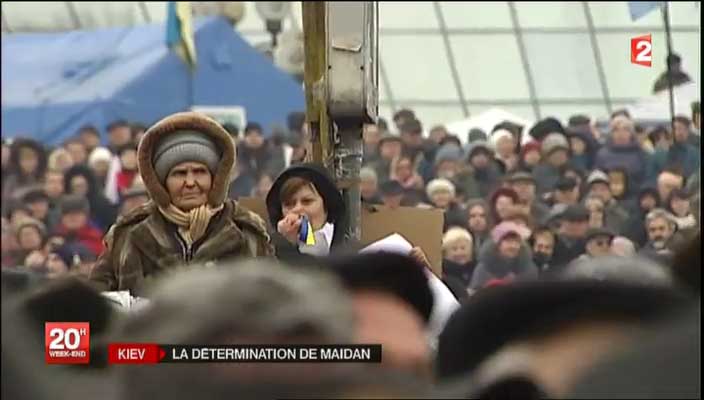 Crowd at Maidan Square including a woman blowing her nose on the Ukrainian flag
